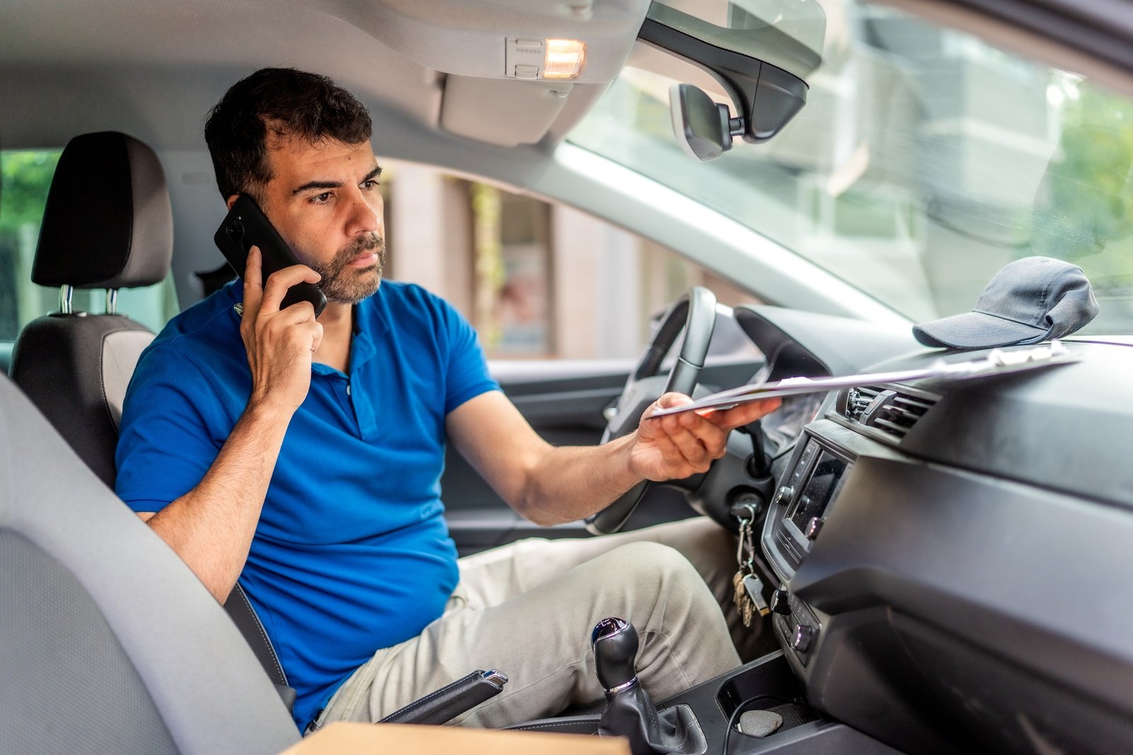 Delivery person talking to the mobile phone inside a van